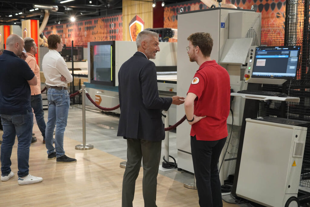 Collega van De Groot praat met klant bij cnc-machine in de showroom
