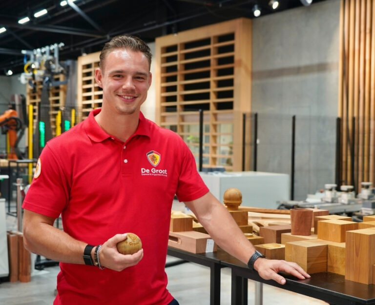 Collega staat in showroom met houtproduct in de hand.