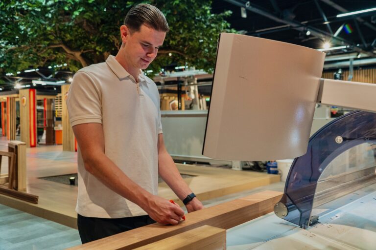 De Groot'er werkt aan cnc-machine in showroom en tekent hout af.