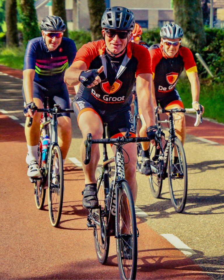 Collega fietst op wiel ren fiets in De Groot sportkleding