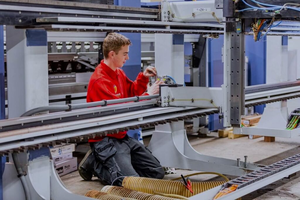 Servicetechnicus werkt aan cnc-machine bij klant op locatie