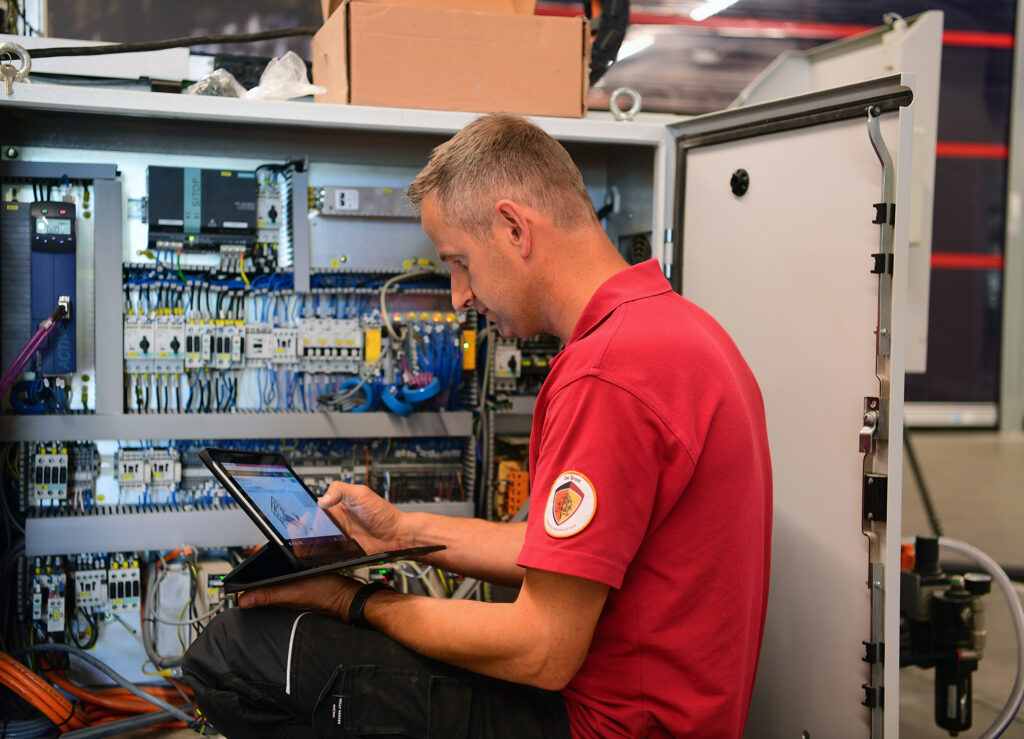 Servicetechnicus checkt de techniek bij een bedrijf zit voor elektriciteitskast